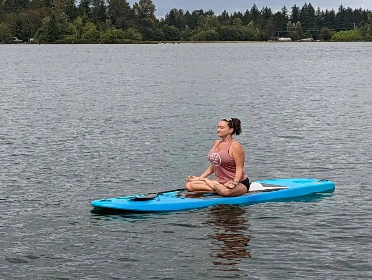 A Woman Meditating on a Blue Surf Boat