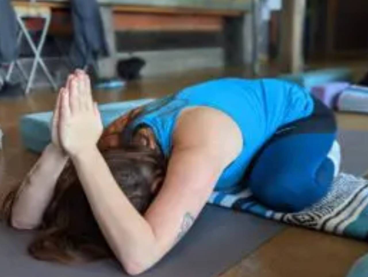 A Woman in Blue Tank Top Doing Yoga