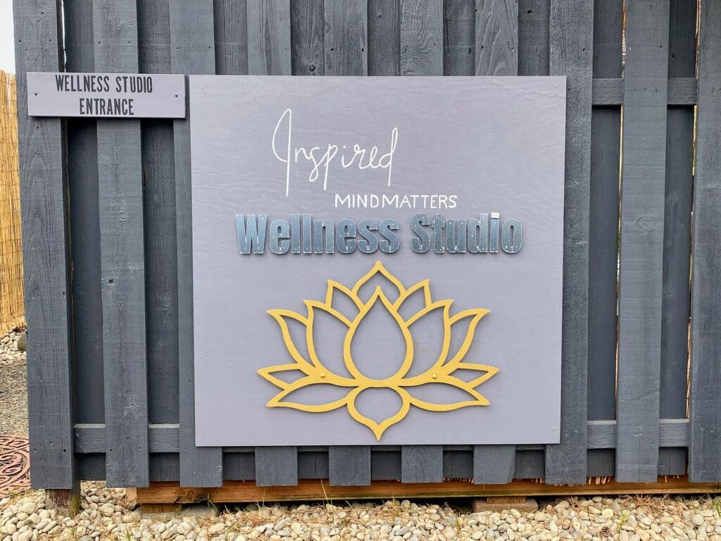 A board of wellness studio with a flower on it